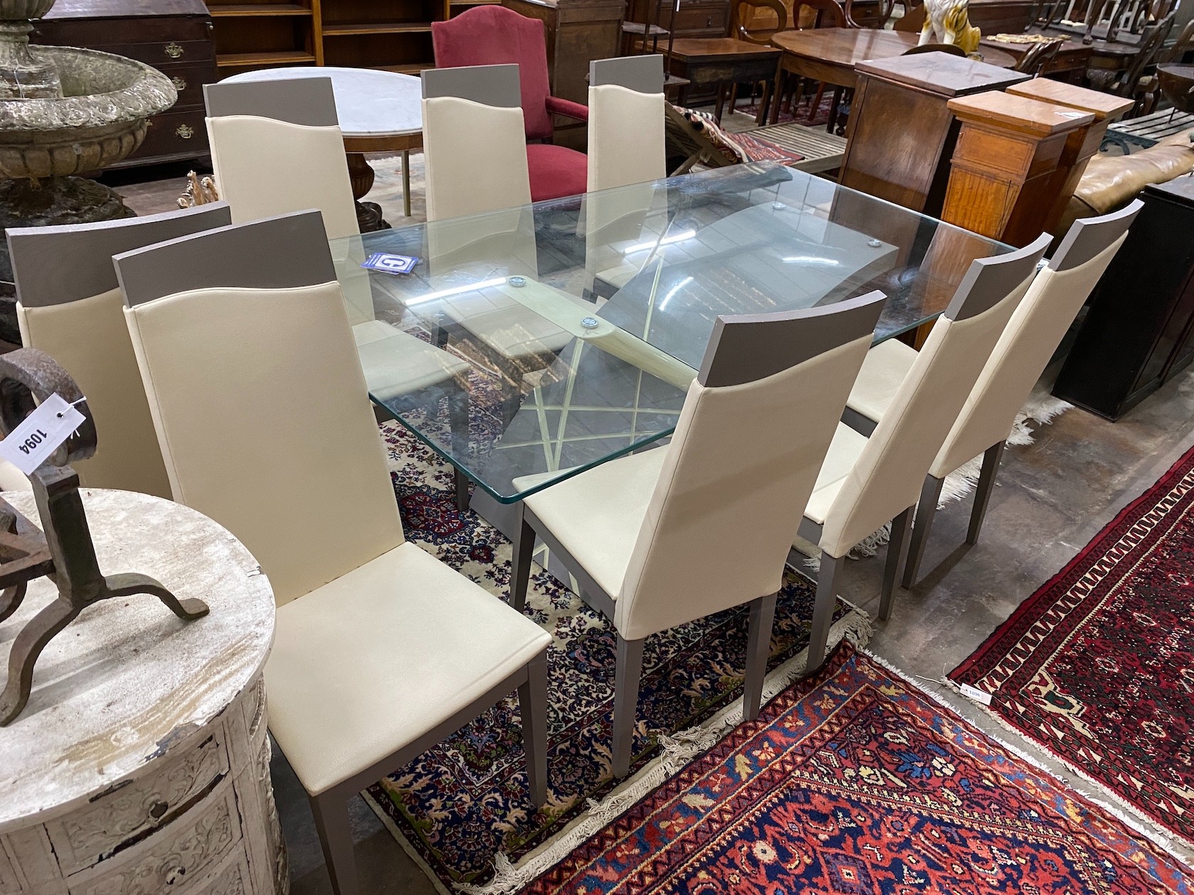 A contemporary rectangular glass topped dining table, length 199cm, depth 107cm, height 78cm and a set of eight cream leather high back chairs